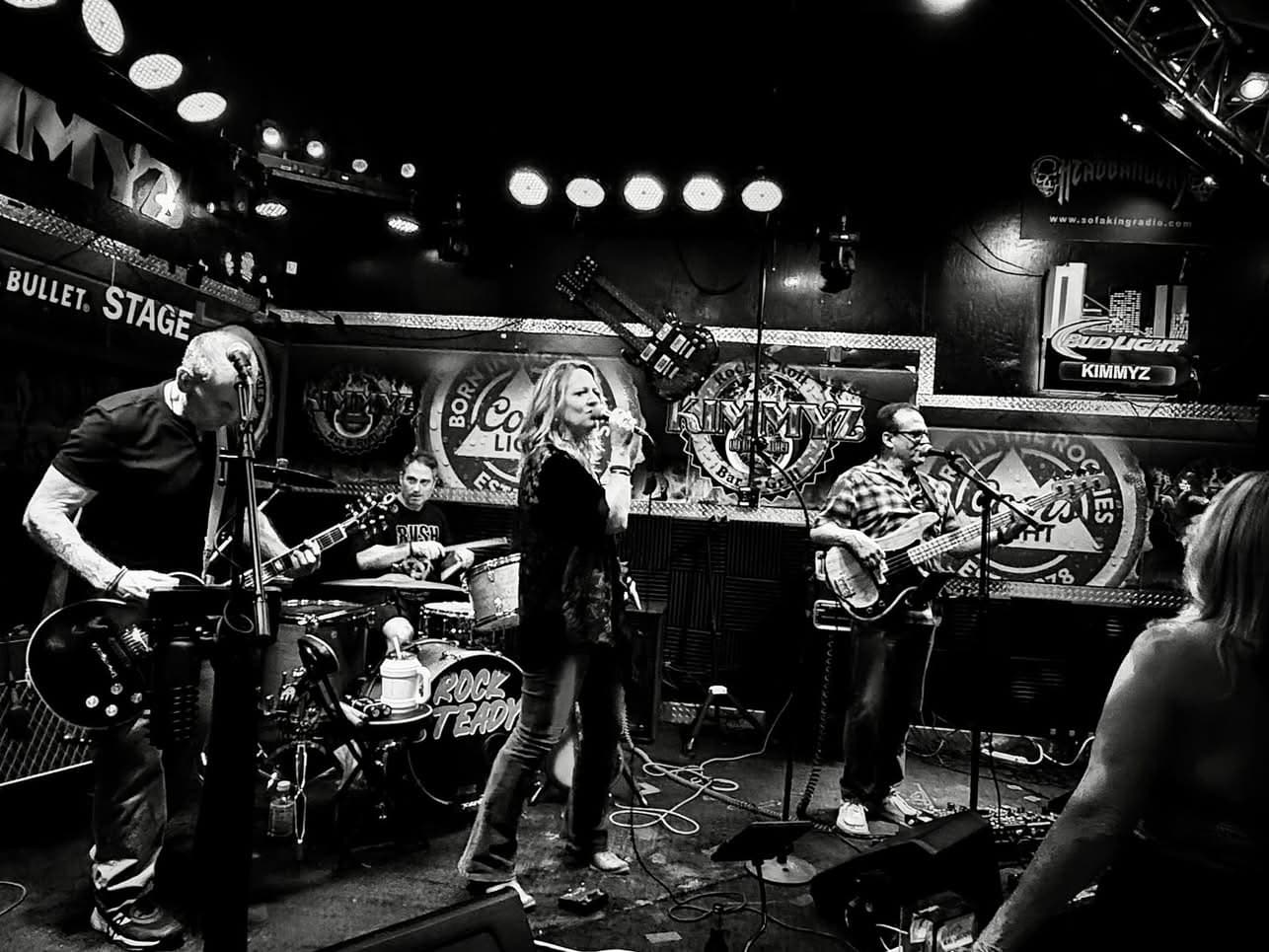 Wide black and white photo of Rock Steady onstage